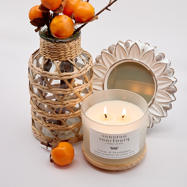 Citrus & Persimmon Tumbler Candle with two lit wicks and persimmon styling
