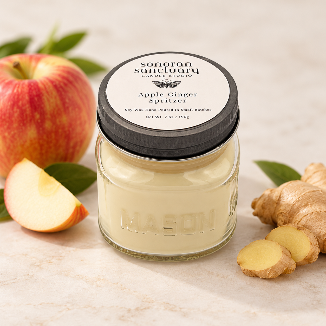 Sonoran Sanctuary Apple Ginger Spritzer kitchen soy candle in a glass mason jar with black lid, styled with fresh red apples, sliced ginger and green botanicals