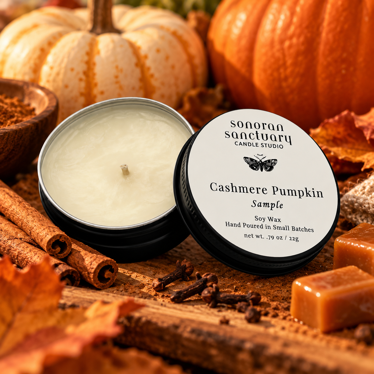 Sonoran Sanctuary Cashmere Pumpkin soy candle sample tin with branded lid, styled with pumpkins, cinnamon sticks, cloves and caramel