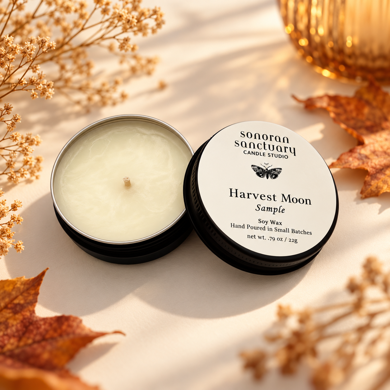 Sonoran Sanctuary Harvest Moon soy candle sample tin with branded lid, styled with autumn leaves, dried botanicals and warm golden lighting